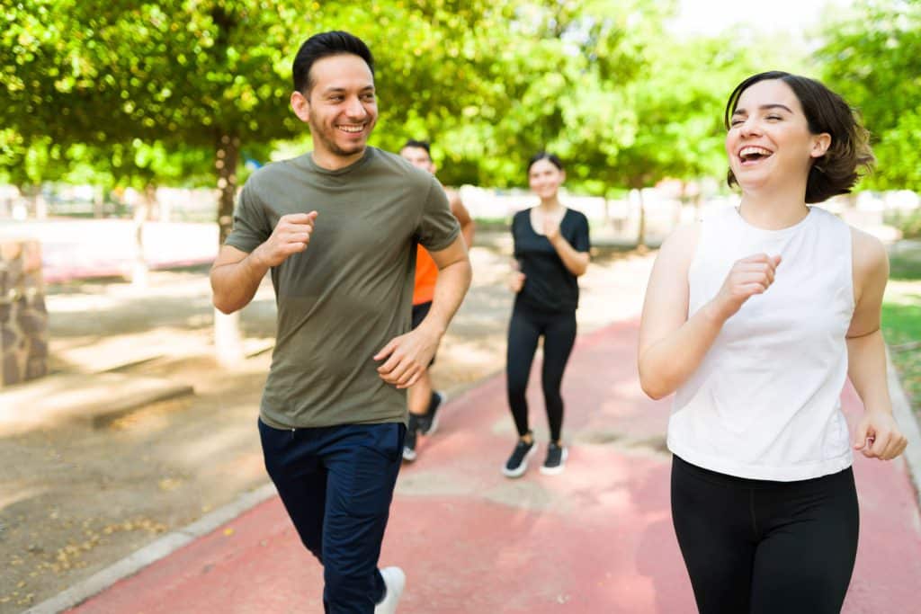 Happy young woman and man enjoying a run